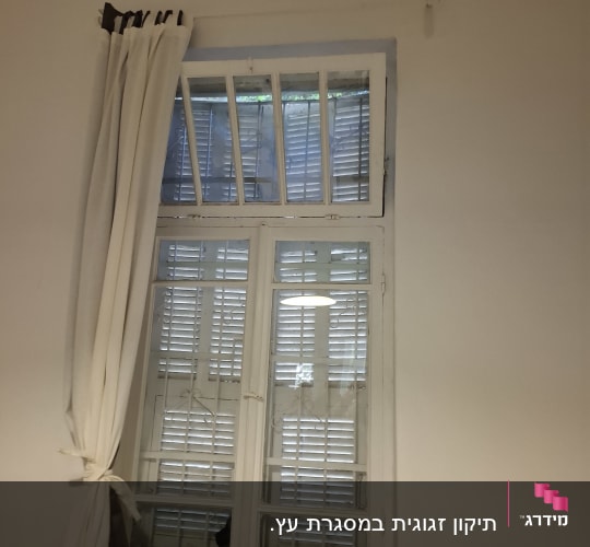 חלון זכוכית משובץ במסגרת עץ לבנה בחדר